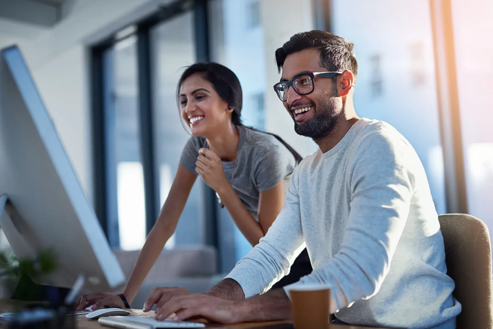 Two colleagues reviewing content blocks and media galleries on screen in a Truvio Commerce workspace